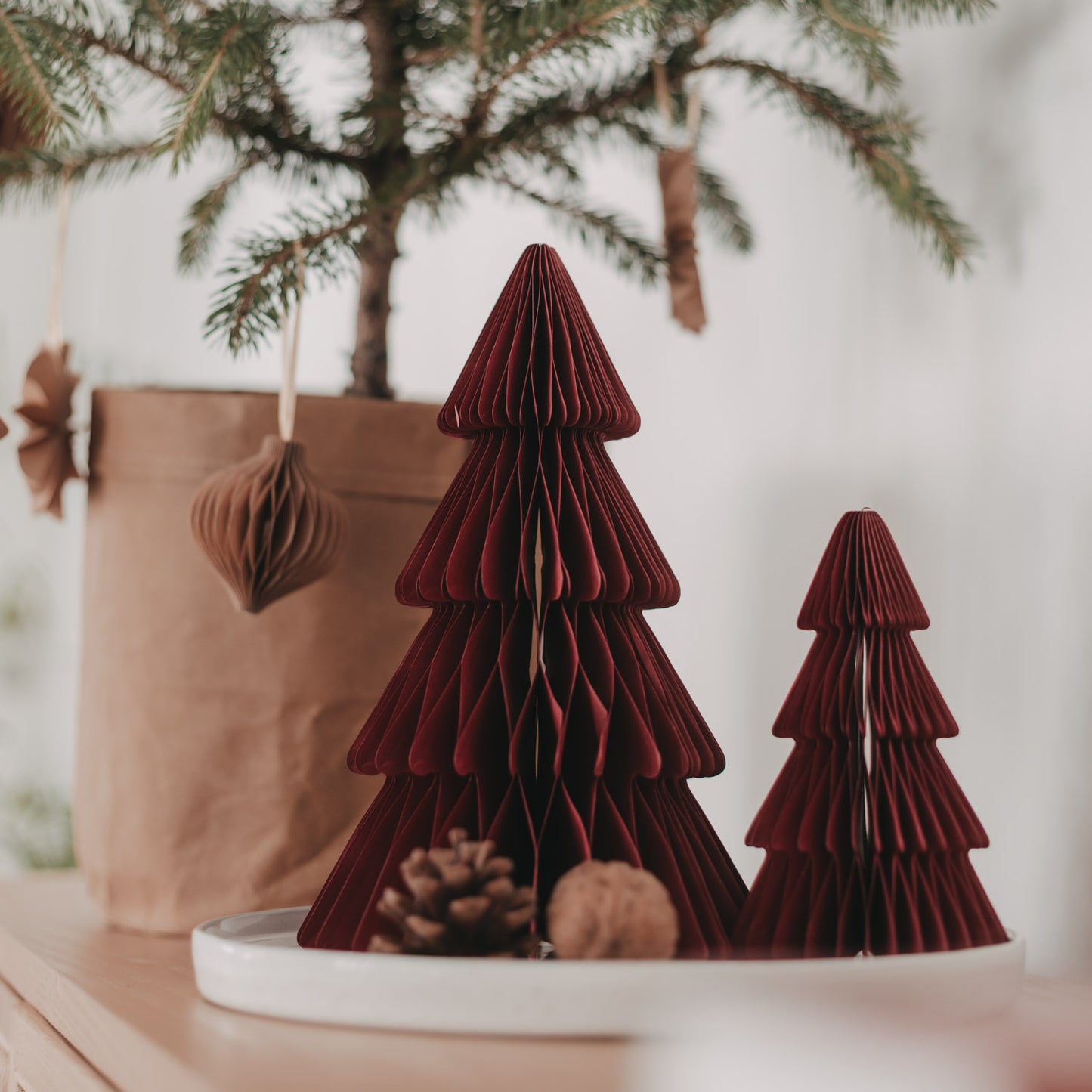 Dunkelrote Papiertannen in zwei Größen auf einem Tablett als festliche Weihnachtsdeko
