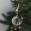 Grauer Papieranhänger in Kugelform am Weihnachtsbaum