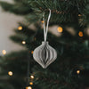 Grauer Weihnachtsanhänger in Kugelform aus Papier am Tannenbaum