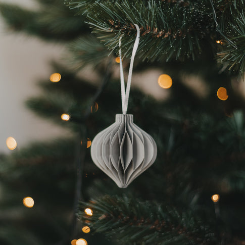 Grauer Weihnachtsanhänger in Kugelform aus Papier am Tannenbaum