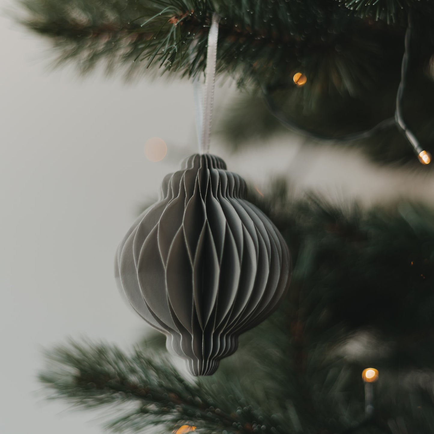Grauer Weihnachtsanhänger aus Papier in Kugelform als stilvoller Christbaumschmuck