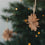 Braune Papierschneeflocke aus Papier als Weihnachtsbaumschmuck am Tannenzweig