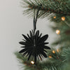 Schwarze Papierschneeflocke als Weihnachtsanhänger am festlich geschmückten Christbaum
