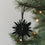 Schwarze Papierschneeflocke als Weihnachtsanhänger am festlich geschmückten Christbaum