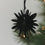 Schwarze Papierschneeflocke aus Papier als Weihnachtsbaumschmuck am Tannenzweig