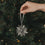 Graue Papierschneeflocke als Weihnachtsanhänger für den Christbaum