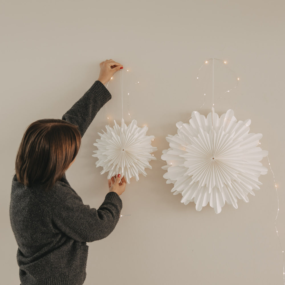 Weiße Papierschneeflocken in 20 cm und 30 cm als festliche Wanddekoration