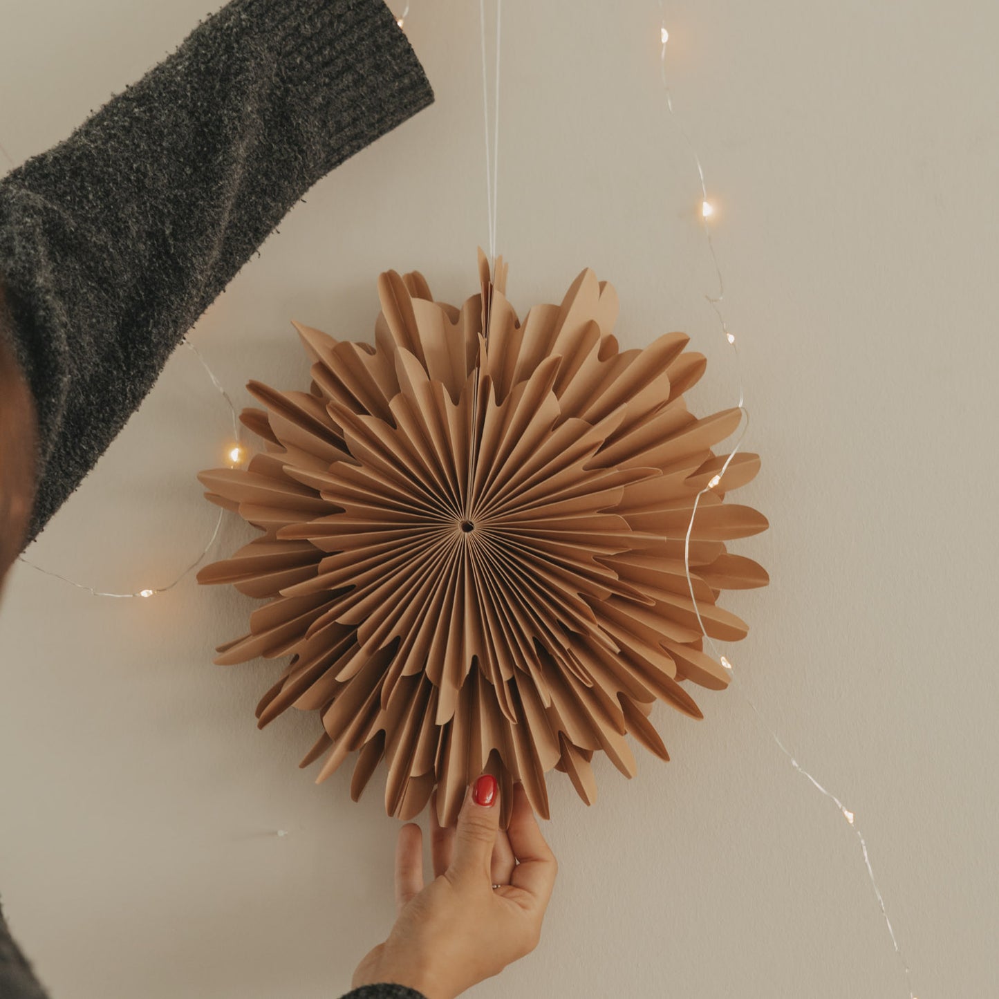 Braune Papierschneeflocke 30 cm an der Wand als festliche Weihnachtsdekoration