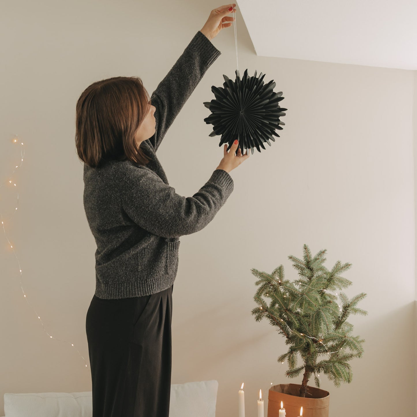 Schwarze Papierschneeflocke 30 cm wird im Wohnraum als festliche Dekoration aufgehängt