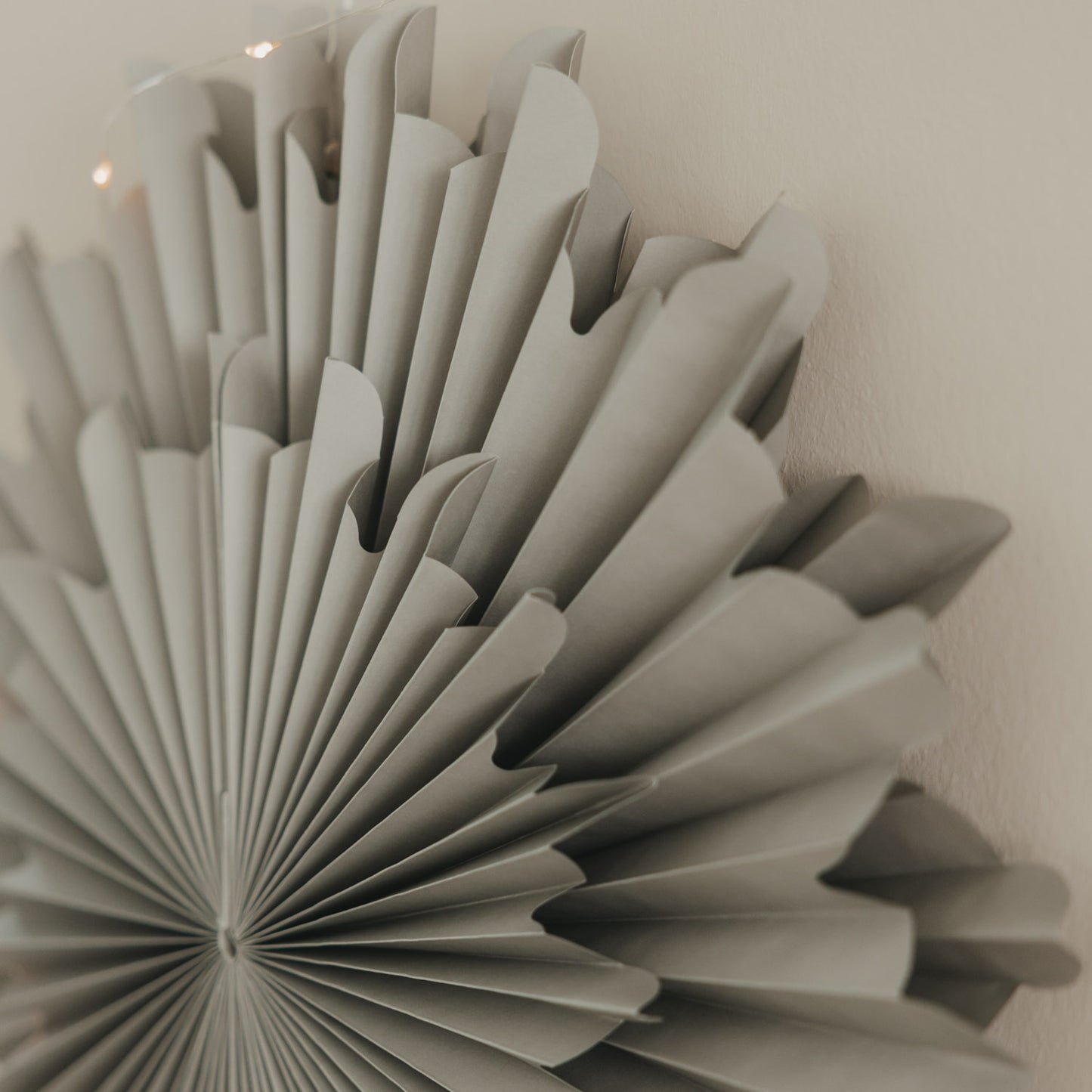 Detailaufnahme der grauen Papierschneeflocke 30 cm mit filigraner Faltstruktur