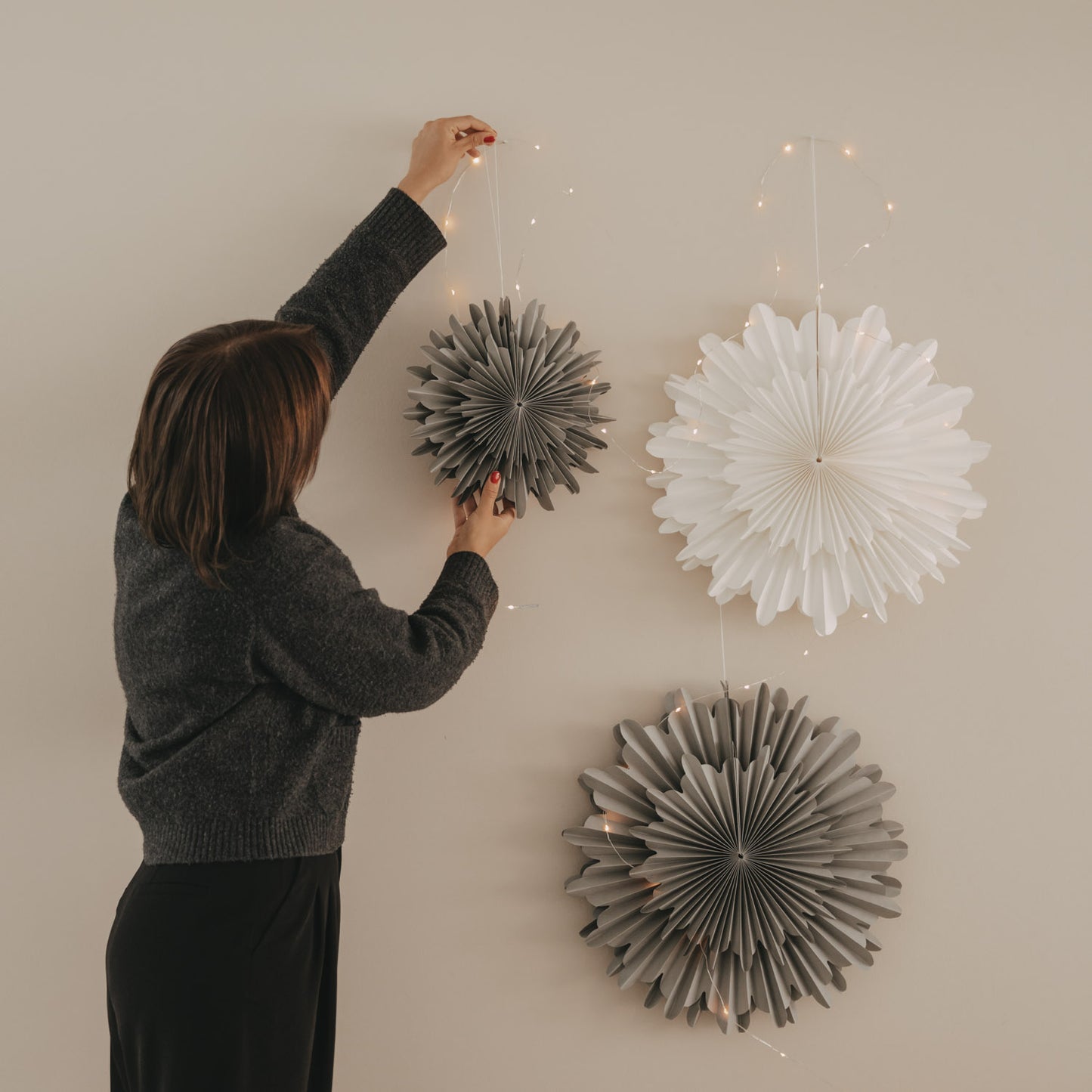 Graue Papierschneeflocke 30 cm neben weißer Papierschneeflocke als Wanddekoration