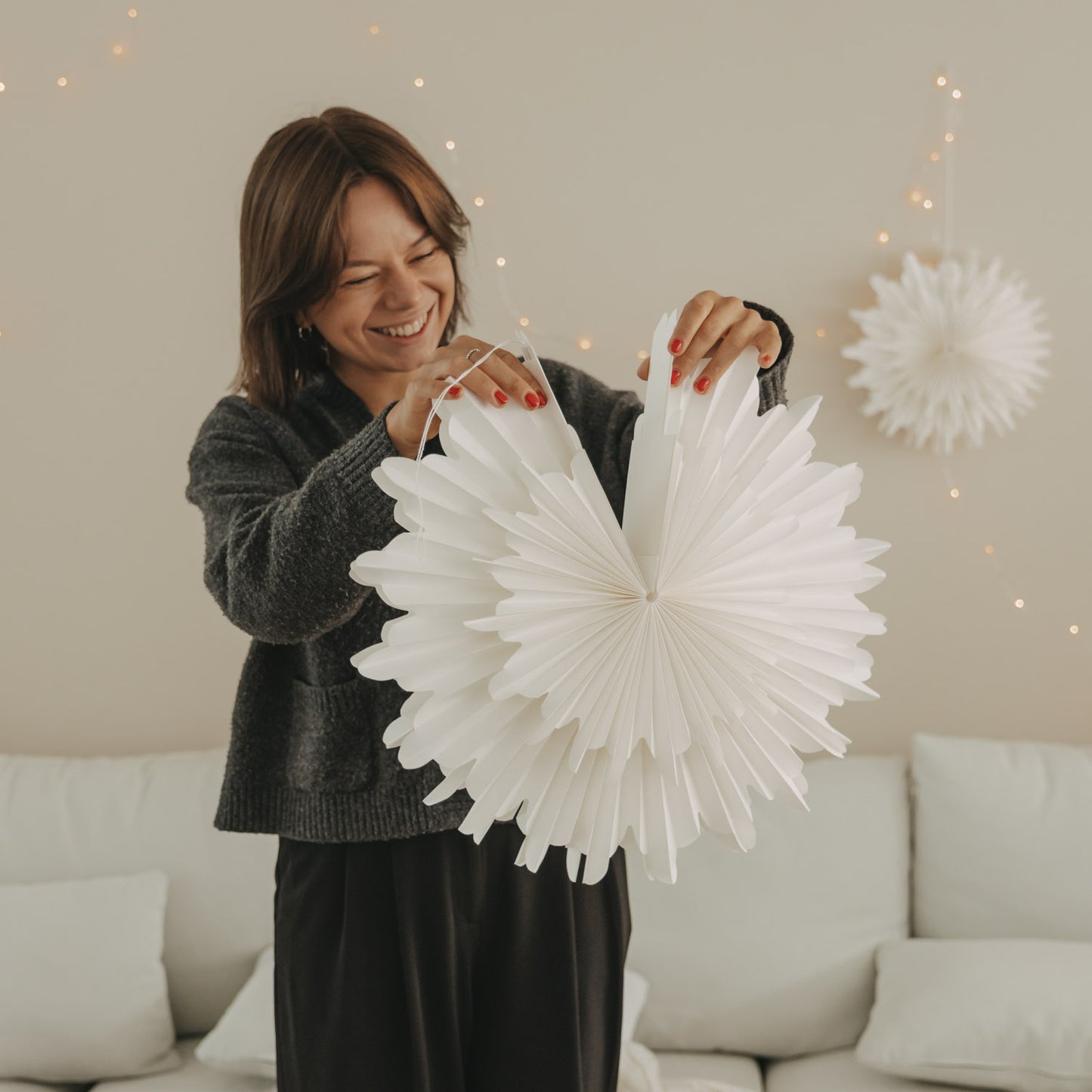 Weiße Papierschneeflocke 45 cm wird aufgefaltet und als Weihnachtsdeko vorbereitet