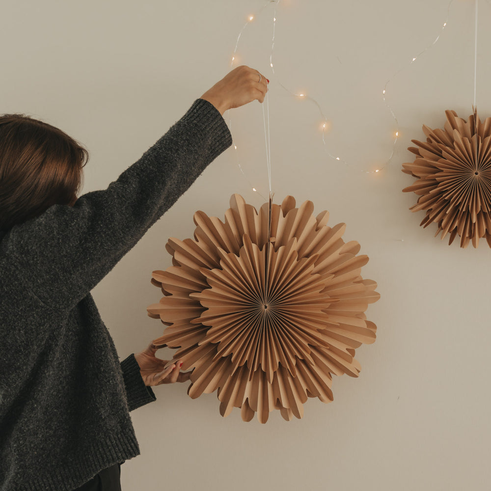 Braune Papierschneeflocke 45 cm wird als Weihnachtsdekoration an der Wand aufgehängt