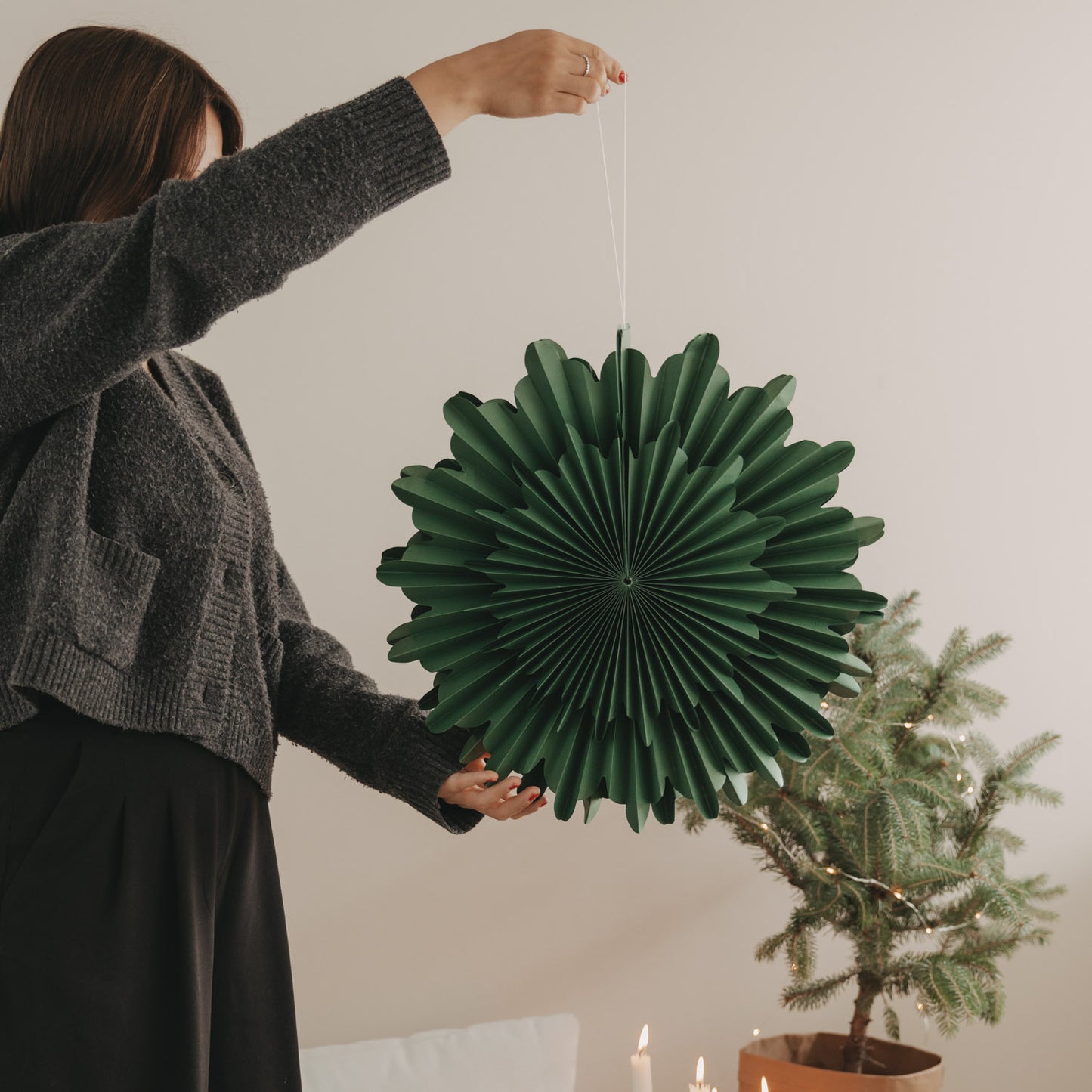 Grüne Papierschneeflocke 45 cm wird als Weihnachtsdekoration aufgehängt
