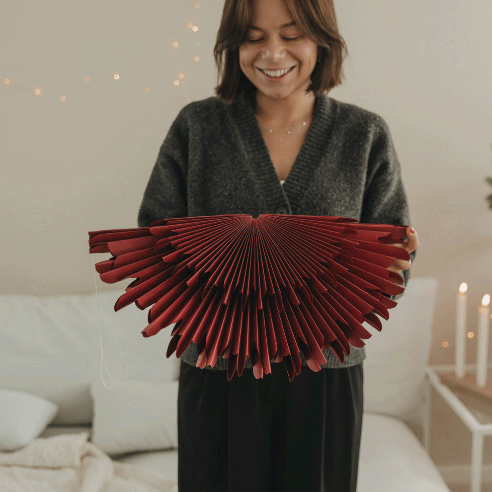 Rote Papierschneeflocke 45 cm wird aufgefaltet und als hängende Weihnachtsdekoration präsentiert