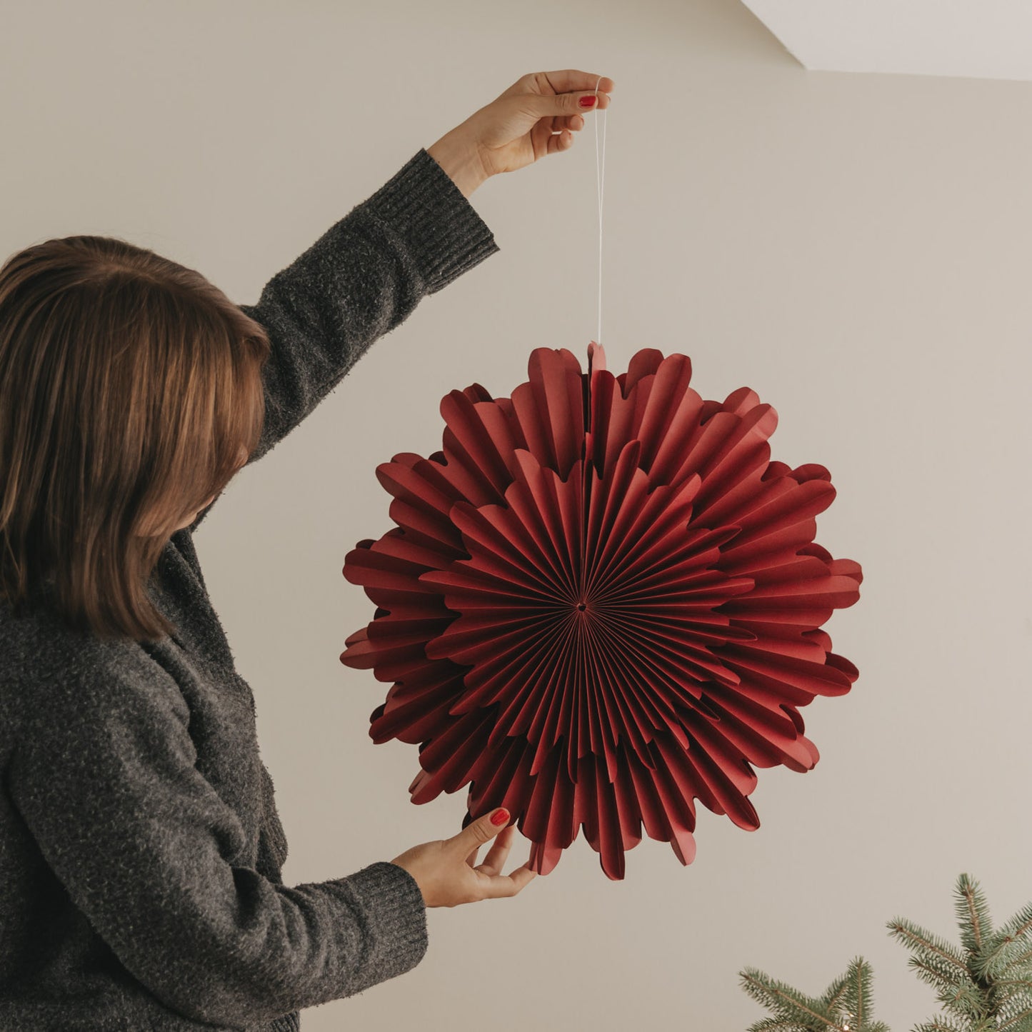 Rote Papierschneeflocke 45 cm wird als moderne Weihnachtsdekoration aufgehängt