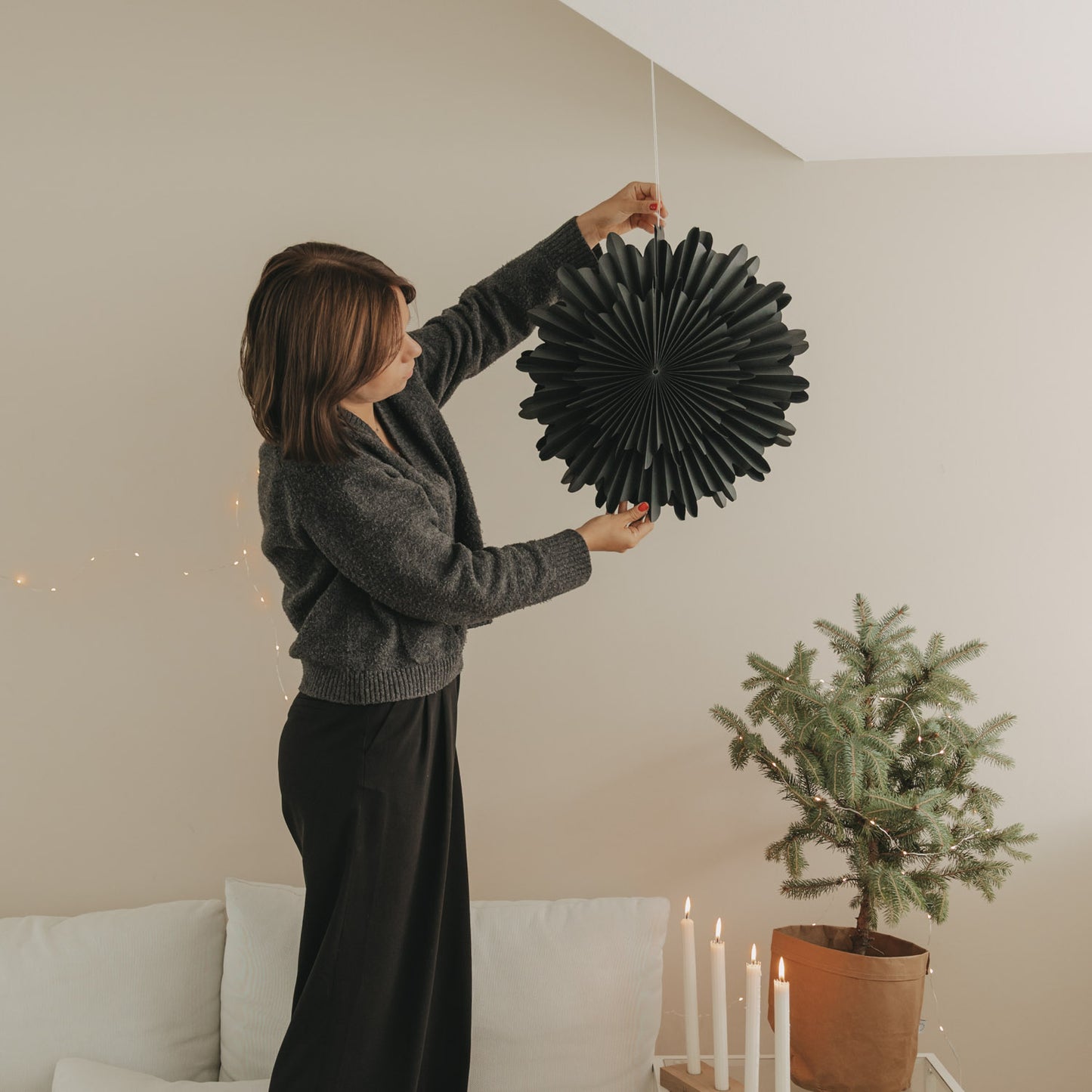 Schwarze Papierschneeflocke 45 cm wird im Wohnraum als festliche Weihnachtsdekoration aufgehängt