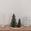 Zwei graue Papiertannen in Wabenoptik mit Kerze und Laterne als minimalistische Weihnachtsdekoration