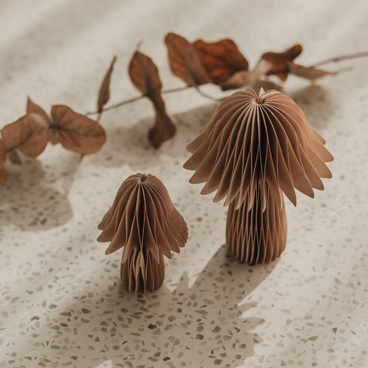 Zwei dekorative Papierpilze in Braun mit getrocknetem Zweig als natürliche Tischdeko im Herbst