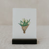 Aquarell-Osterkarte mit gelbem Tulpenstrauß im schwarzen Kartenhalter.