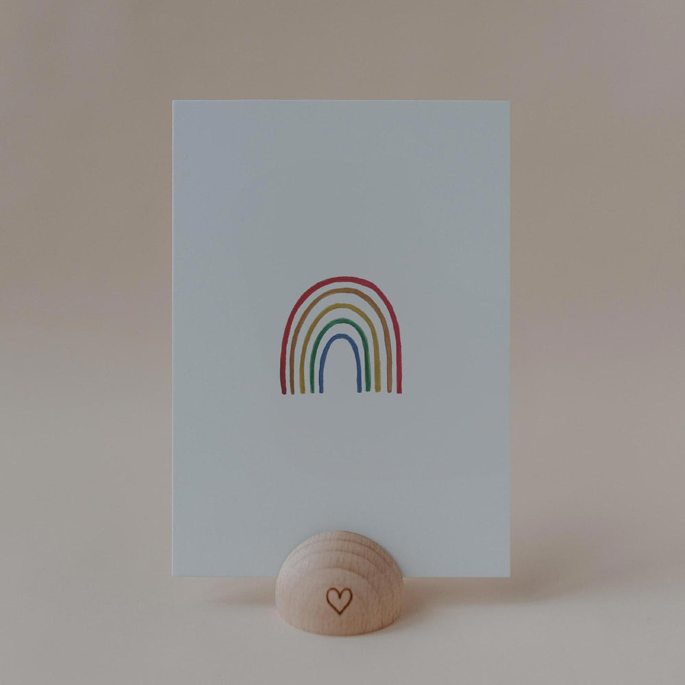 Eulenschnitt Aquarellkarte mit buntem Regenbogen auf hellblauem Hintergrund in einem Kartenhalter aus Holz.