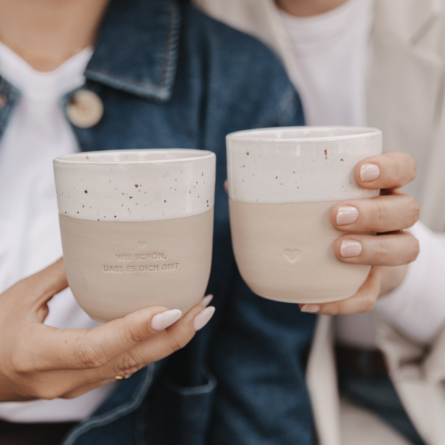 Zwei Hände halten Becher mit Herz und Schriftzug – perfektes Geschenk mit liebevollem Detail.