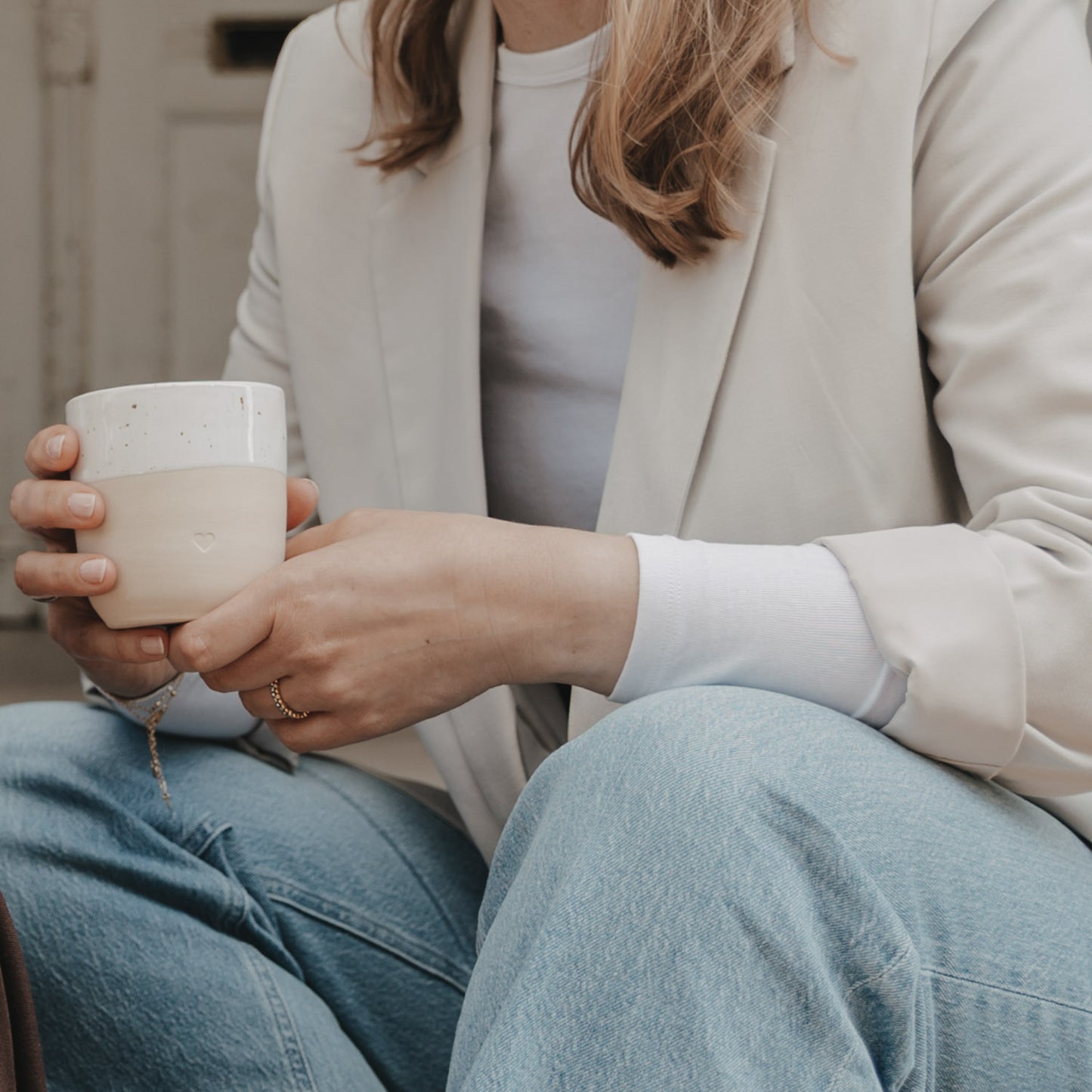 Frau mit Becher Herz in der Hand – schlichtes Design und liebevolles Detail.