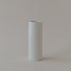 Zylindrische Keramikvase in heller Cremefarbe mit dezent gesprenkelter Glasur. Die Vase steht einzeln auf hellem Hintergrund und hat eine schlichte, elegante Form mit glänzender Oberfläche.