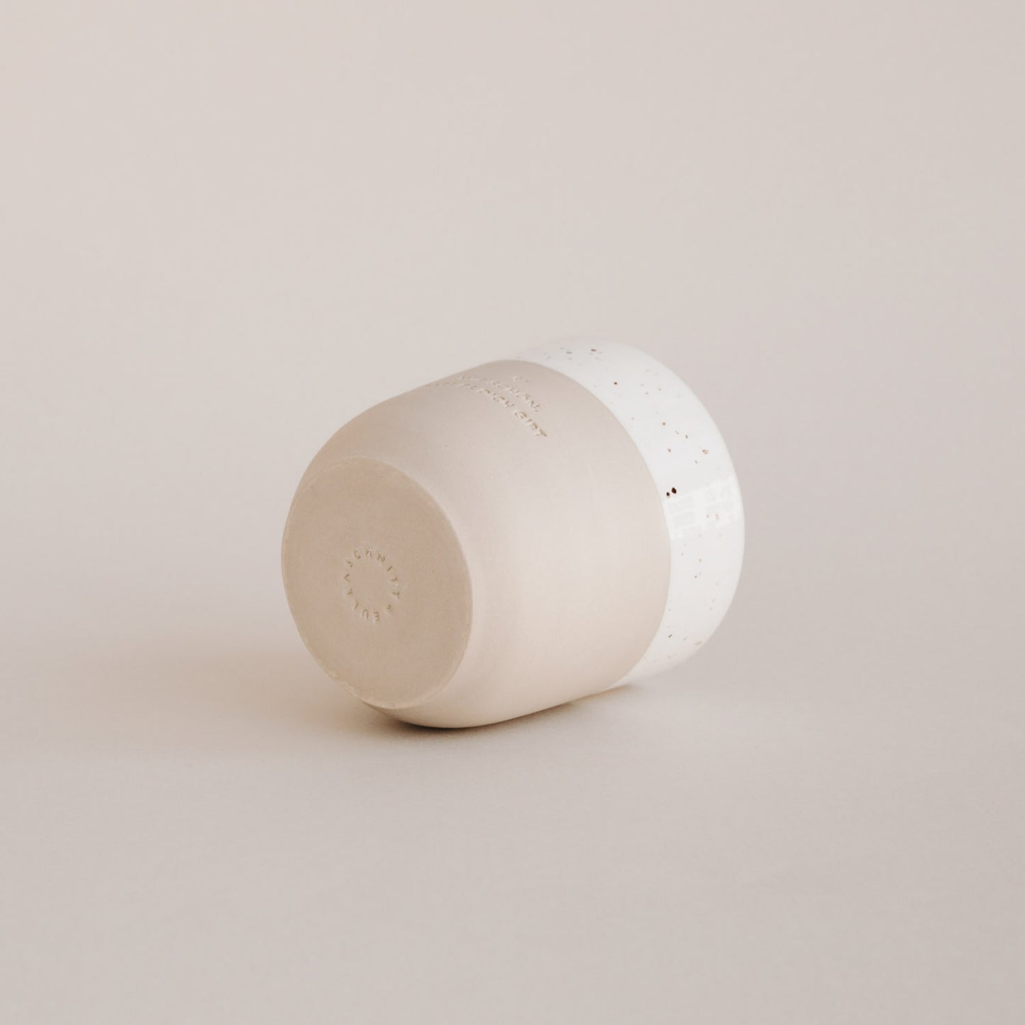 Ein Becher liegt auf der Seite und man kann das Logo Eulenschnitt erkennen und auch die Prägung "Wie schön, dass es dich gibt" auf der Seite.