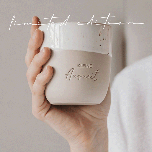 Keramikbecher „Kleine Auszeit“ in sanfter Bewegung, präsentiert in heller, gemütlicher Umgebung – Limited Edition.