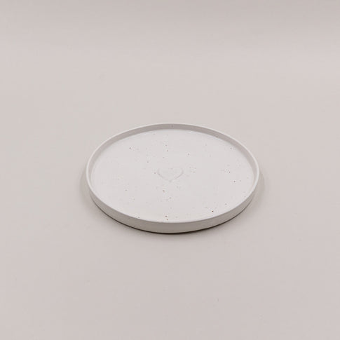 Einzelner Frühstücksteller Calma mit Herzprägung, oben fotografiert auf hellem Untergrund.