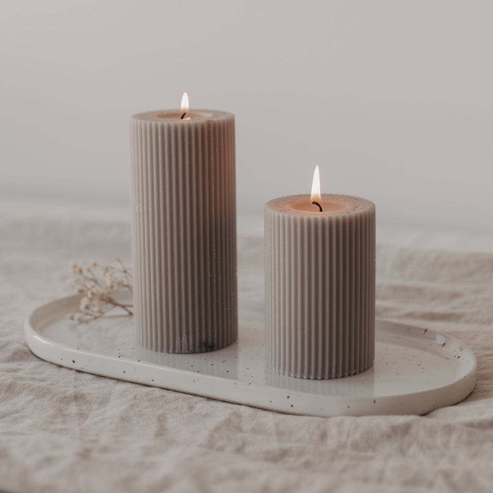Kleine Servierplatte Calma dekoriert mit zwei brennenden Stumpenkerzen – stimmungsvolle Atmosphäre