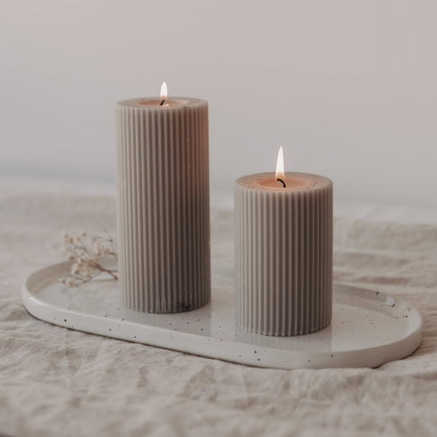 Kleine Servierplatte Calma dekoriert mit zwei brennenden Stumpenkerzen – stimmungsvolle Atmosphäre