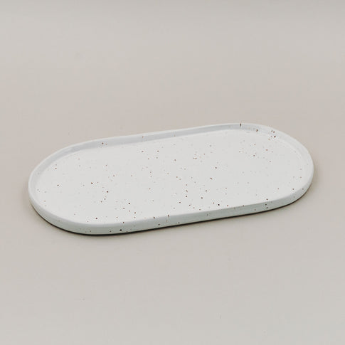 Servierplatte Calma klein aus weißem Steingut mit Sprenkelmuster auf hellem Untergrund