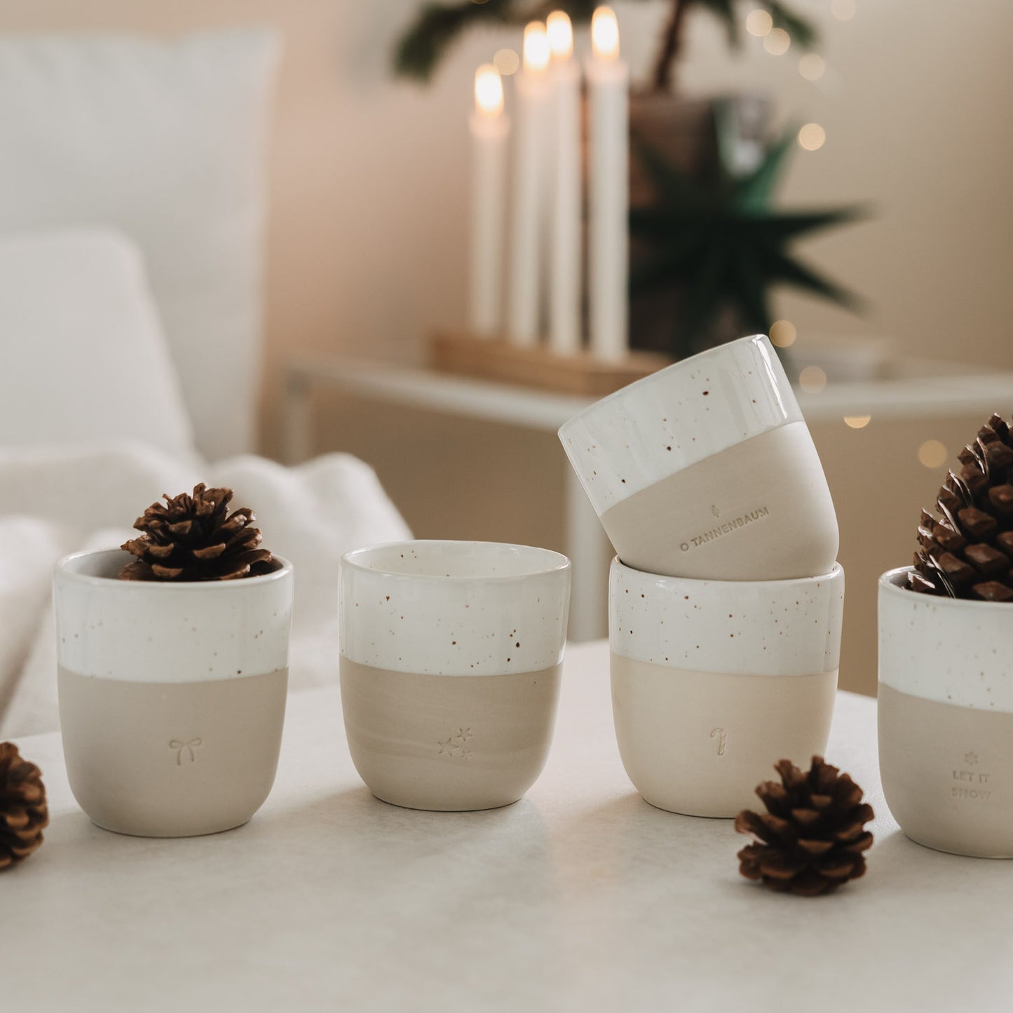 Keramikbecher Set mit Weihnachtsmotiven und Tannenzapfen, stilvolle winterliche Tischdekoration