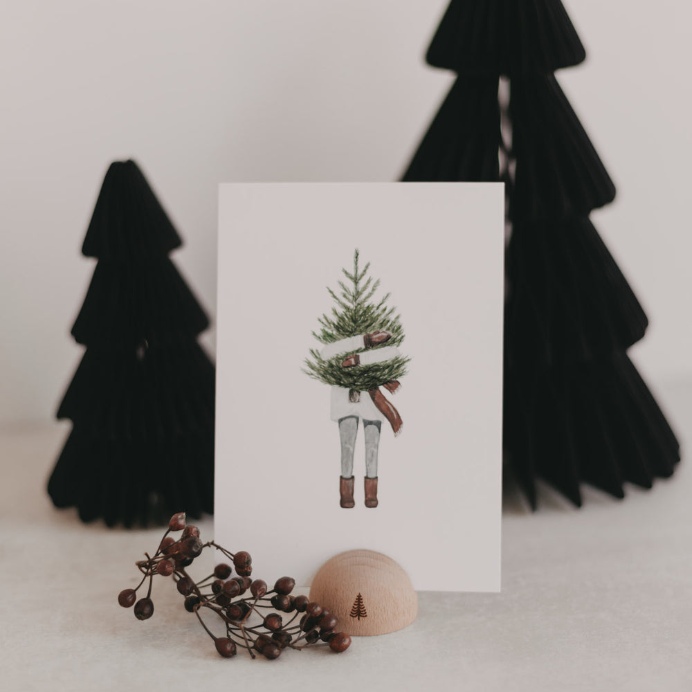 Kartenständer Halbrund Tanne mit Postkarte und Deko vor schwarzen Papierbäumen