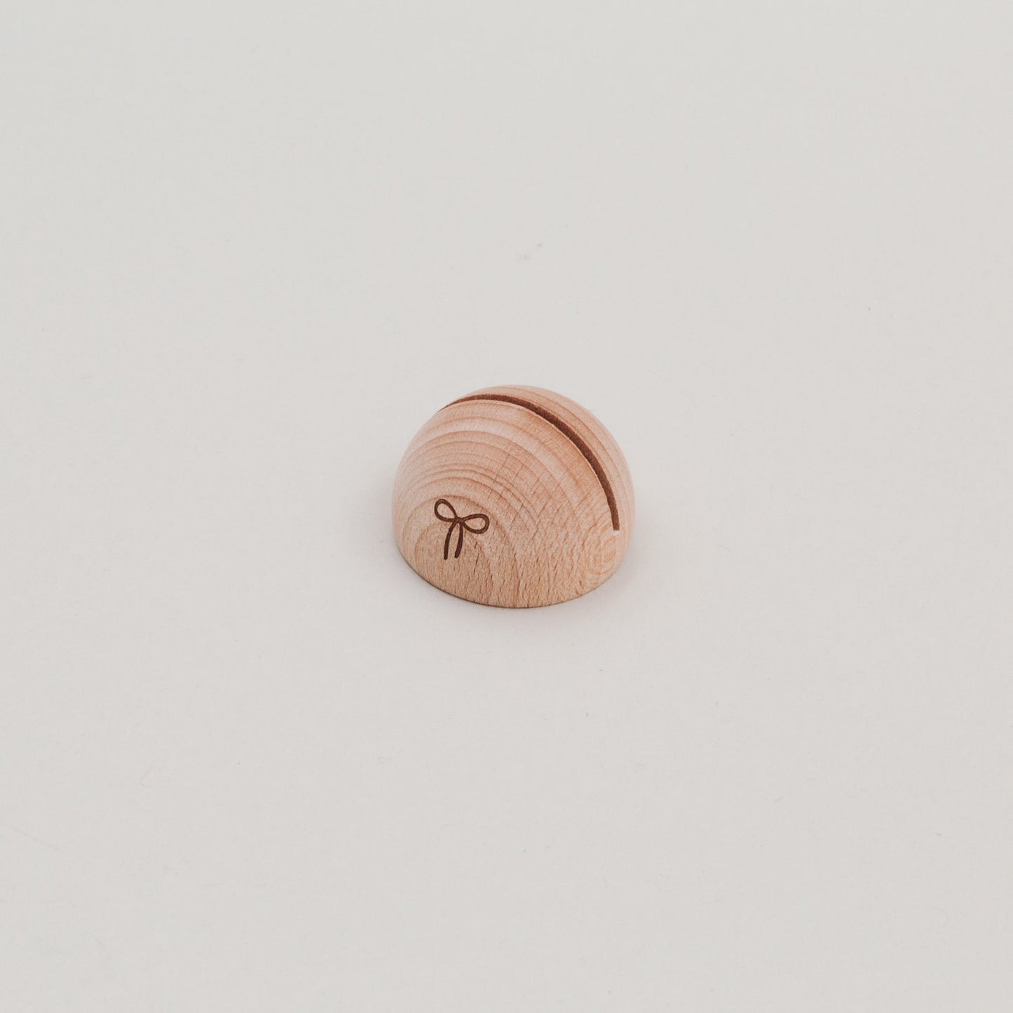 Kartenhalter halbrund aus Holz mit Schlitz und Schleifen-Gravur, seitlich auf weißem Untergrund fotografiert