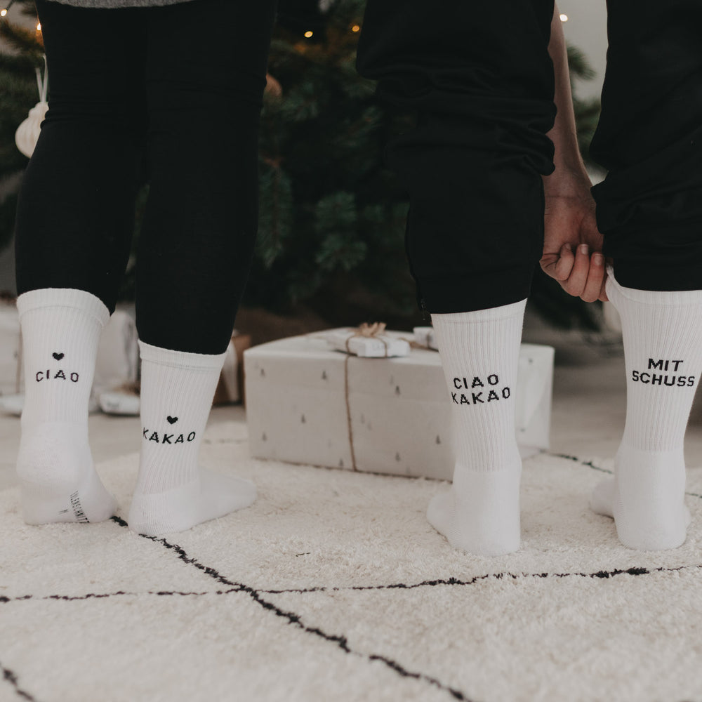 Zwei Personen tragen passende Ciao Kakao und Mit Schuss Socken als weihnachtliches Partner-Set