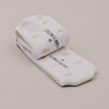 Gefaltete weiße Socken mit Daisy-Muster und Eulenschnitt Logo in Detailaufnahme
