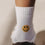 Detailaufnahme der weißen Kids Socken mit gelbem Smiley