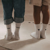 Weiße Kids Socken Große Schwester mit schwarzem Schriftzug neben Kindersocken mit schwarzen Herzen