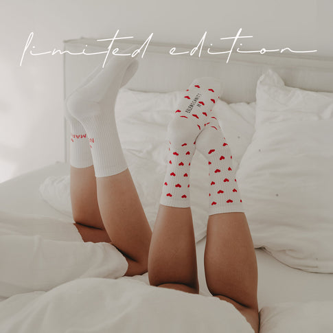 Zwei Personen liegen nebeneinander im Bett und strecken die Beine in die Luft. Die eine trägt Socken mit Herzchen-Muster und die andere Socken mit dem Schriftzug NOT MARRIED. Schriftzug Limited Edition ist über dem Bild eingeblendet.