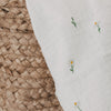 Detail Musselintuch mit kleinen Blumen und Blättern auf weißem Baumwollstoff