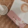 Streichholzschachtel „Kleine Auszeit“ mit Kranichen neben Buch und Kaffeetasse