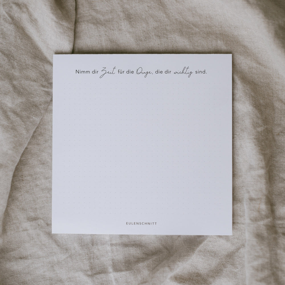 Quadratischer Notizblock mit Punkt­raster und dem Spruch „Nimm dir Zeit für die Dinge, die dir wichtig sind“. Minimalistisches Design.