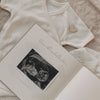 Geöffnetes Schwangerschaftstagebuch mit eingeklebtem Ultraschallbild auf Babybody liegend.