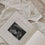 Geöffnetes Schwangerschaftstagebuch mit eingeklebtem Ultraschallbild auf Babybody liegend.