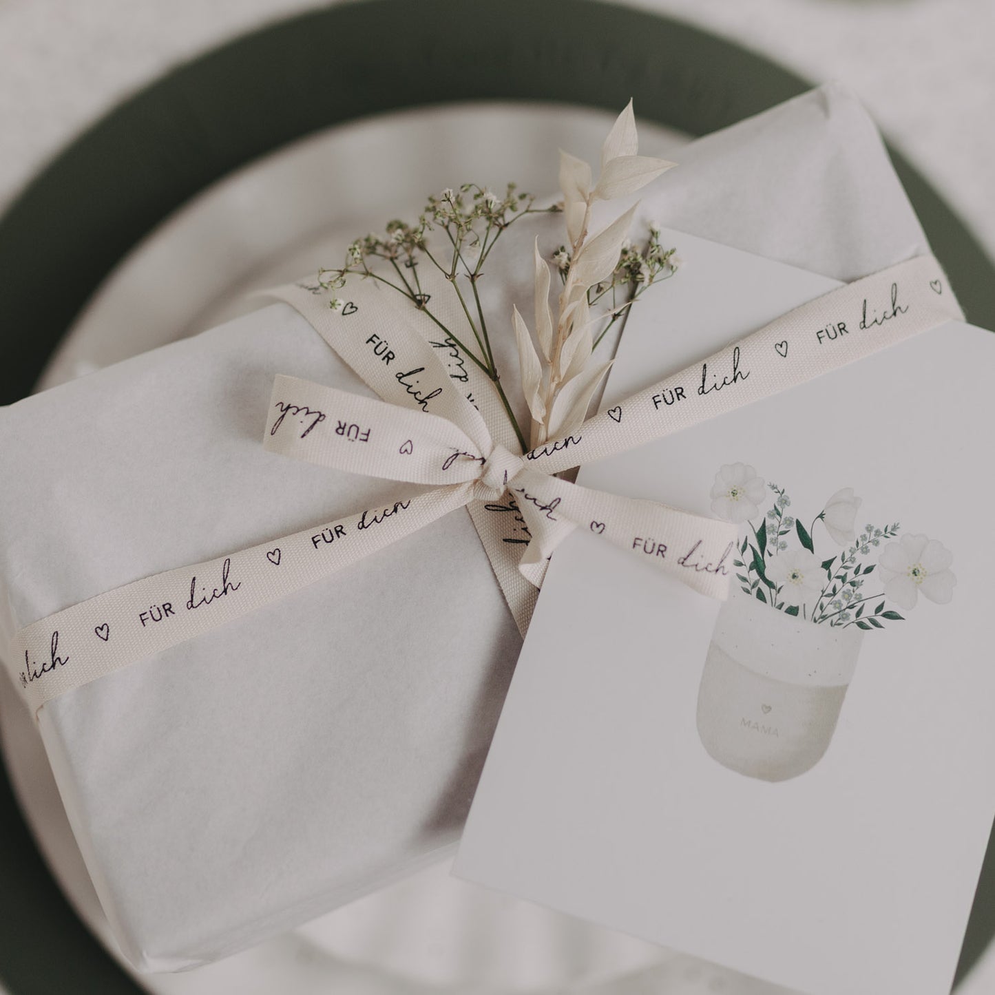 Verpacktes Geschenk mit Geschenkband „Für dich“ und Trockenblumen.