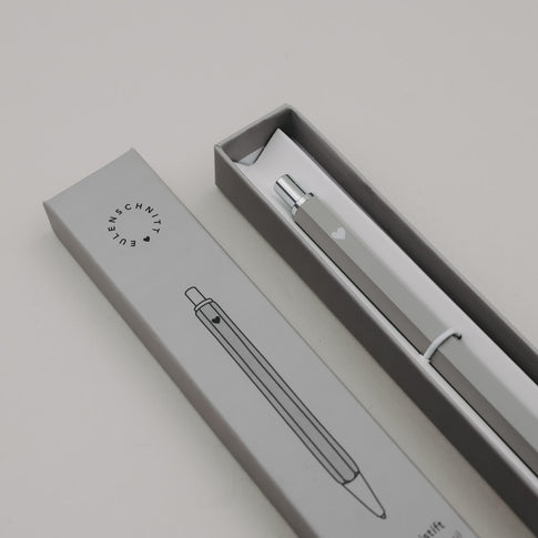 Grauer Druckbleistift in Geschenkbox mit schlichtem Design und Herzmotiv.