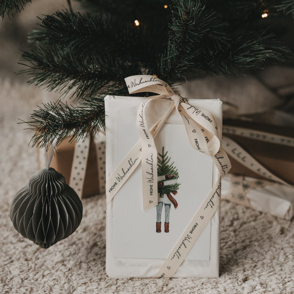 Weihnachtsgeschenk mit beigem Geschenkband Frohe Weihnachten von Eulenschnitt unter dem Weihnachtsbaum